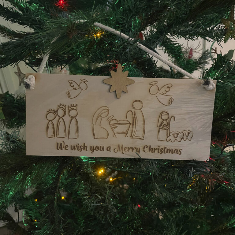 Image of Christmas sign hanging on a tree by Seeds to Sow